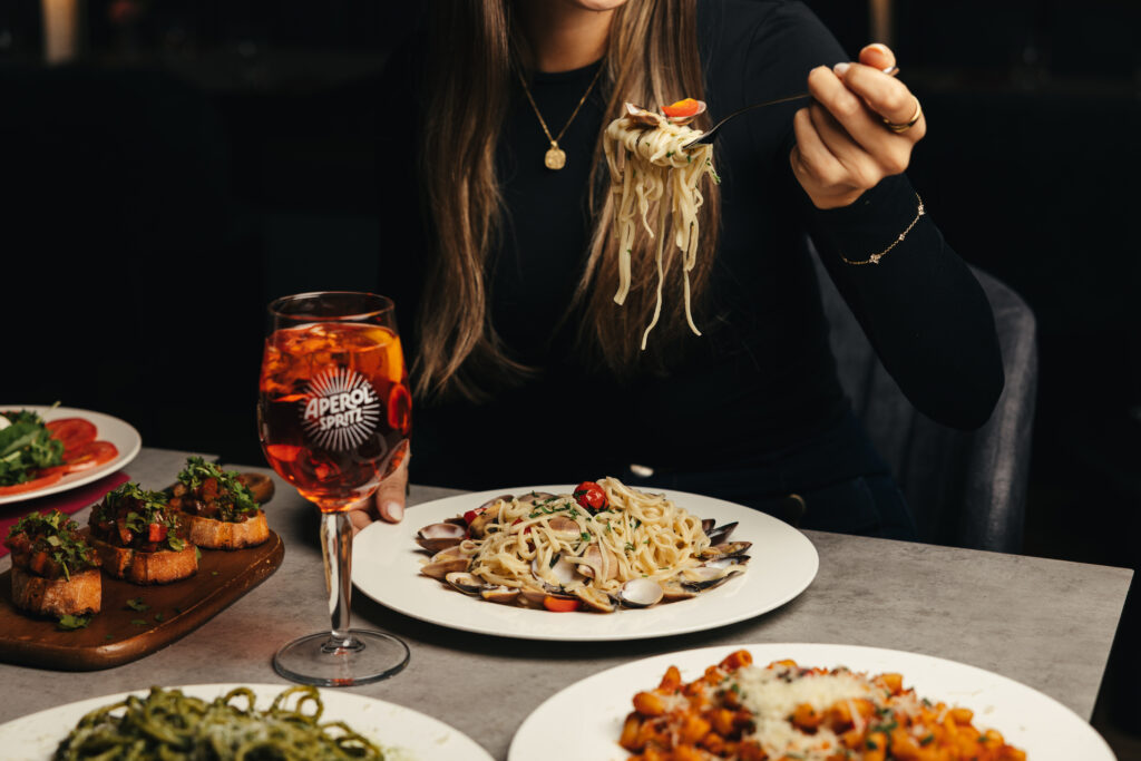 Gäste beim Essen mit Pasta und Antipasti